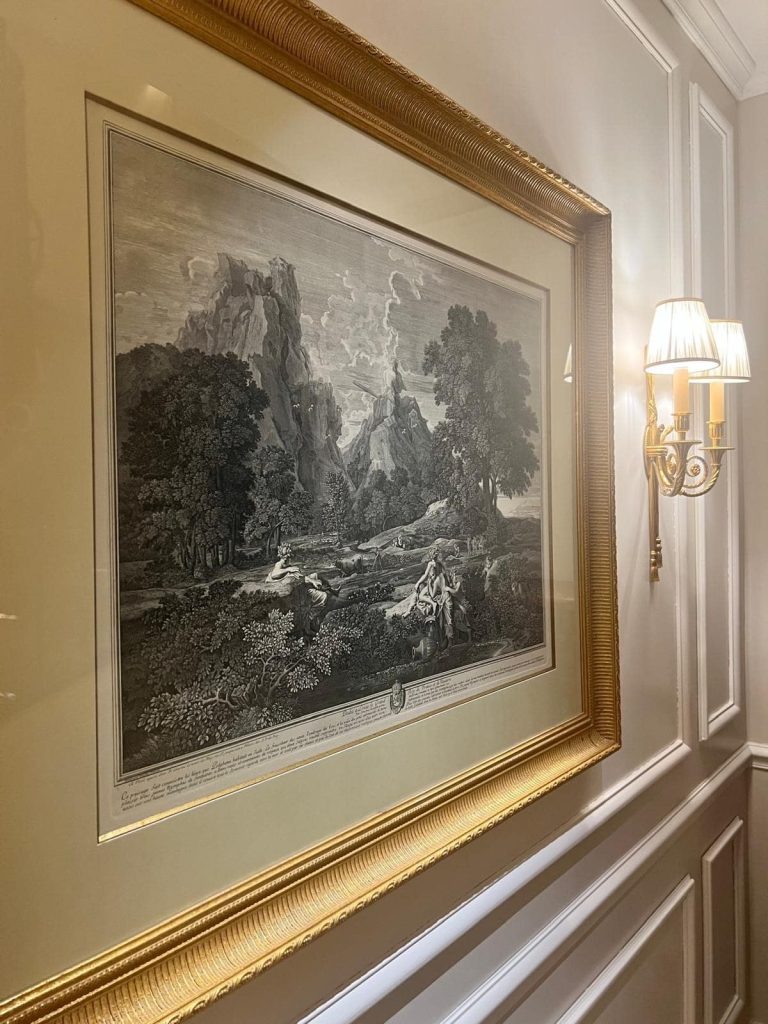 Vintage print in a gold framer on a luxury wall; business travel companions